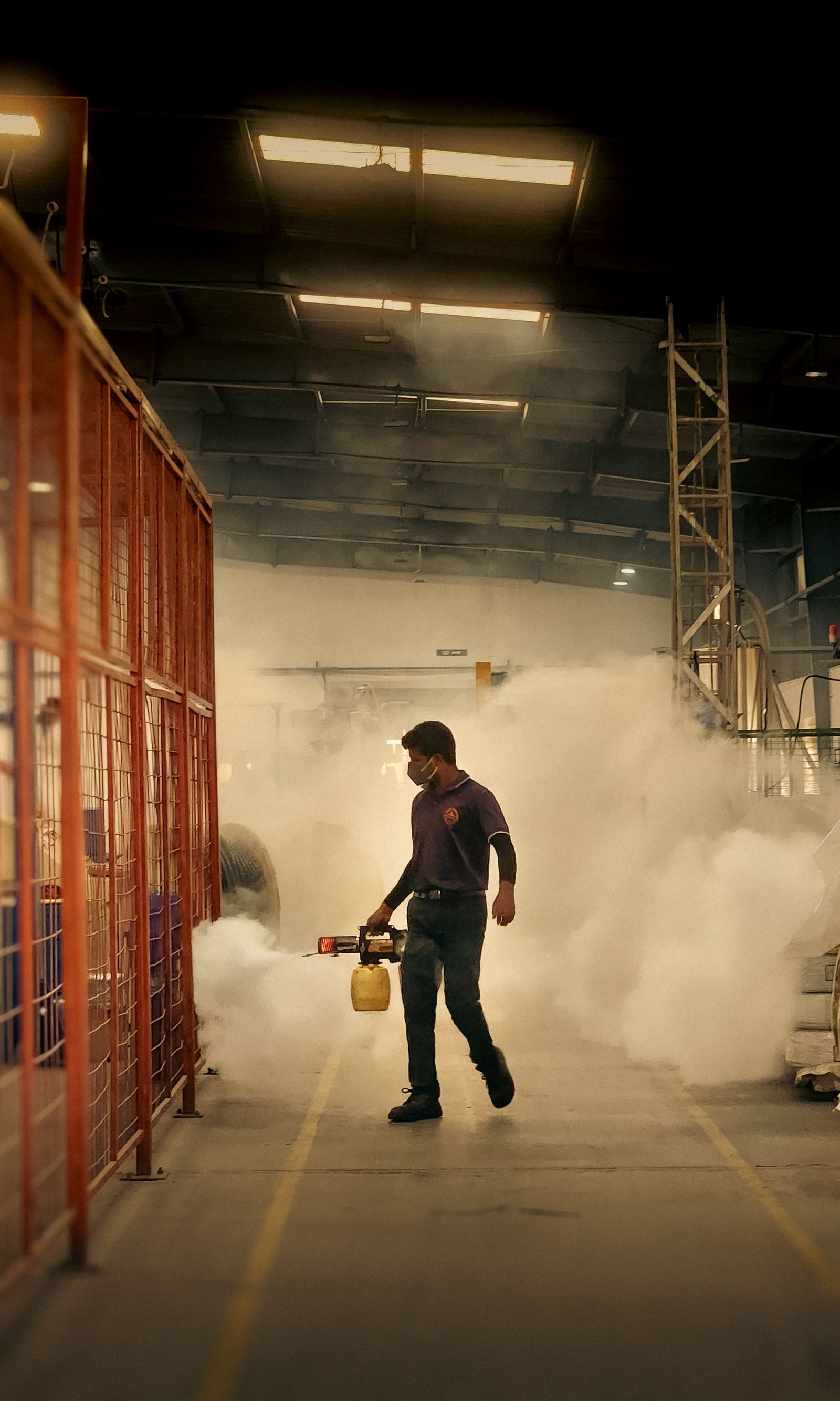 Pest control worker fumigating inside an industrial warehouse
