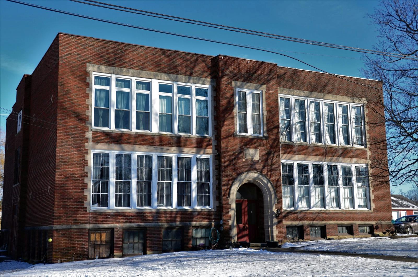 Historic brick school building used to illustrate online registration workflow planning