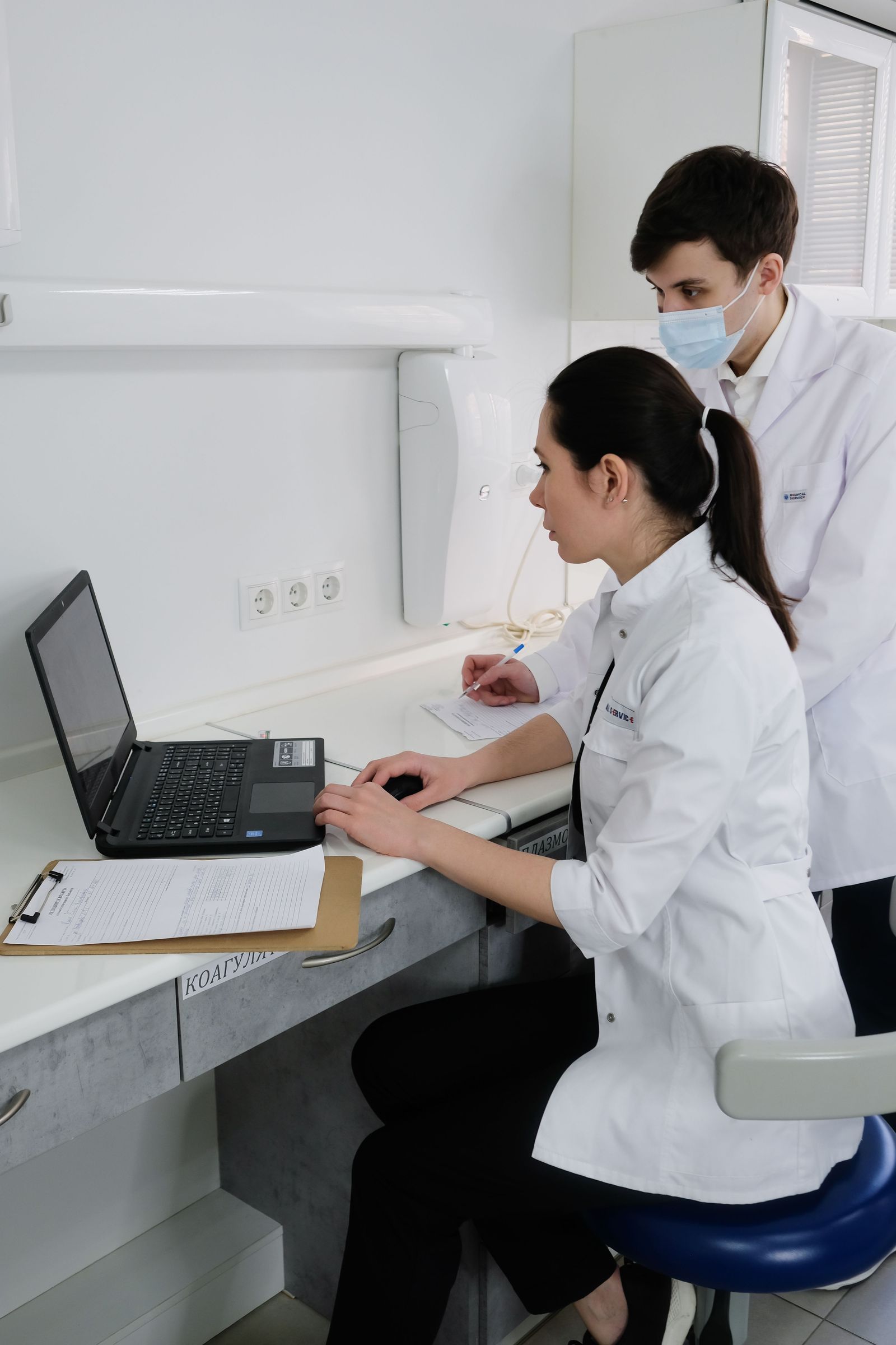 Medical professionals reviewing information together on a laptop in a clinic