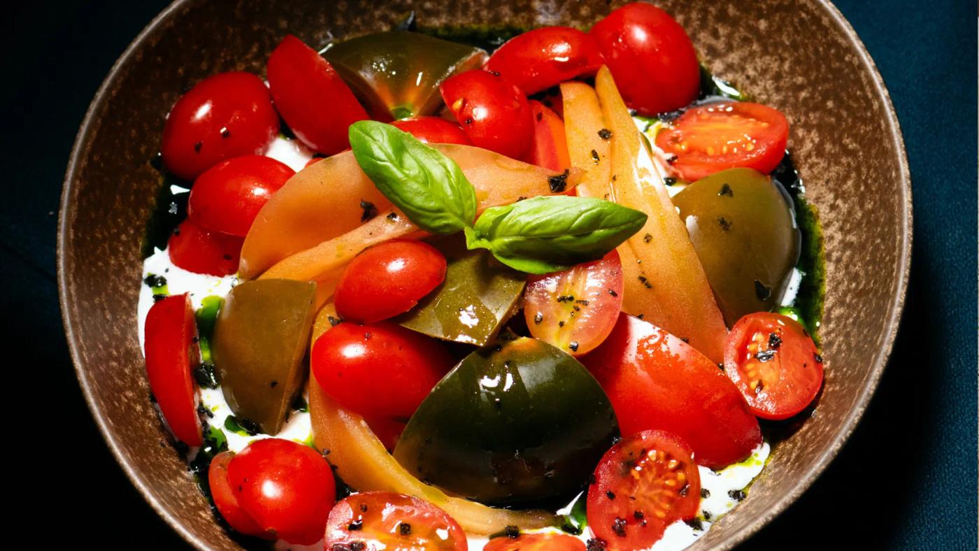 Plat de tomàquets de temporada amb crema d'alfàbrega al restaurant Carnal Steak House de l'Eixample de Barcelona