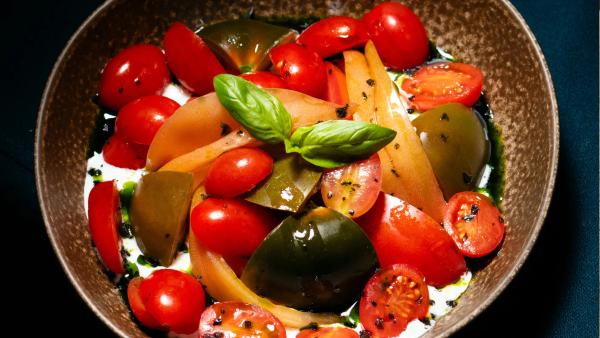 Plat de tomàquets de temporada amb crema d'alfàbrega al restaurant Carnal Steak House de l'Eixample de Barcelona