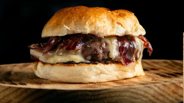 Hamburguesa de vaca de aldea, queso cheddar inglés ahumado, encurtidos en pan de brioche en Carnal Steakhouse, restaurantes Barcelona Eixample