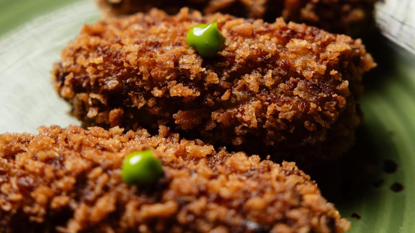 Freshly fried Black Angus cheek croquettes cut in half showing the creamy interior, starter at Carnal Barcelona