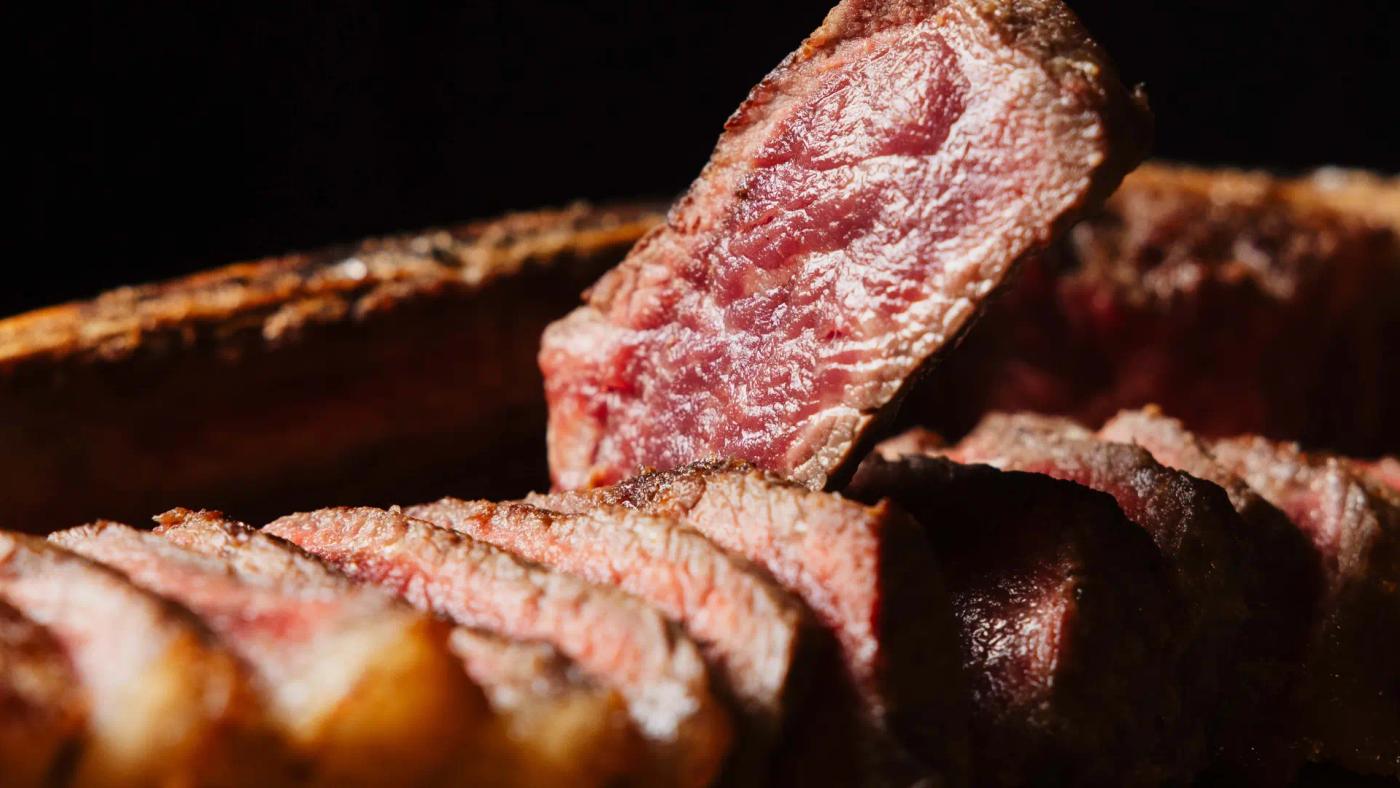 Tres talls de carn a la brasa sobre taula de fusta: entrecot, mitjana i Wagyu, a Carnal Steak House Barcelona