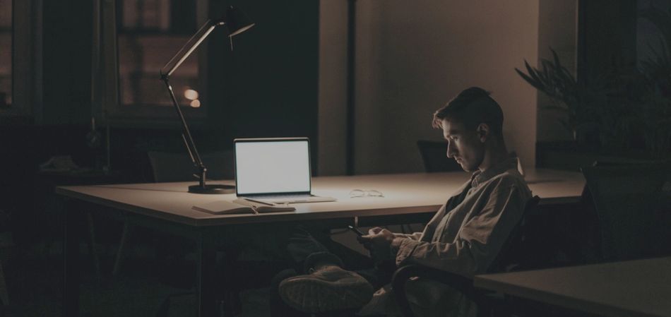 Man working late at desk (Photo by cottonbro)