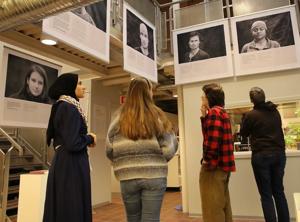 Elever ser på utstillingen "På sporet av frihet" med fotografier av Tom Hatlestad.