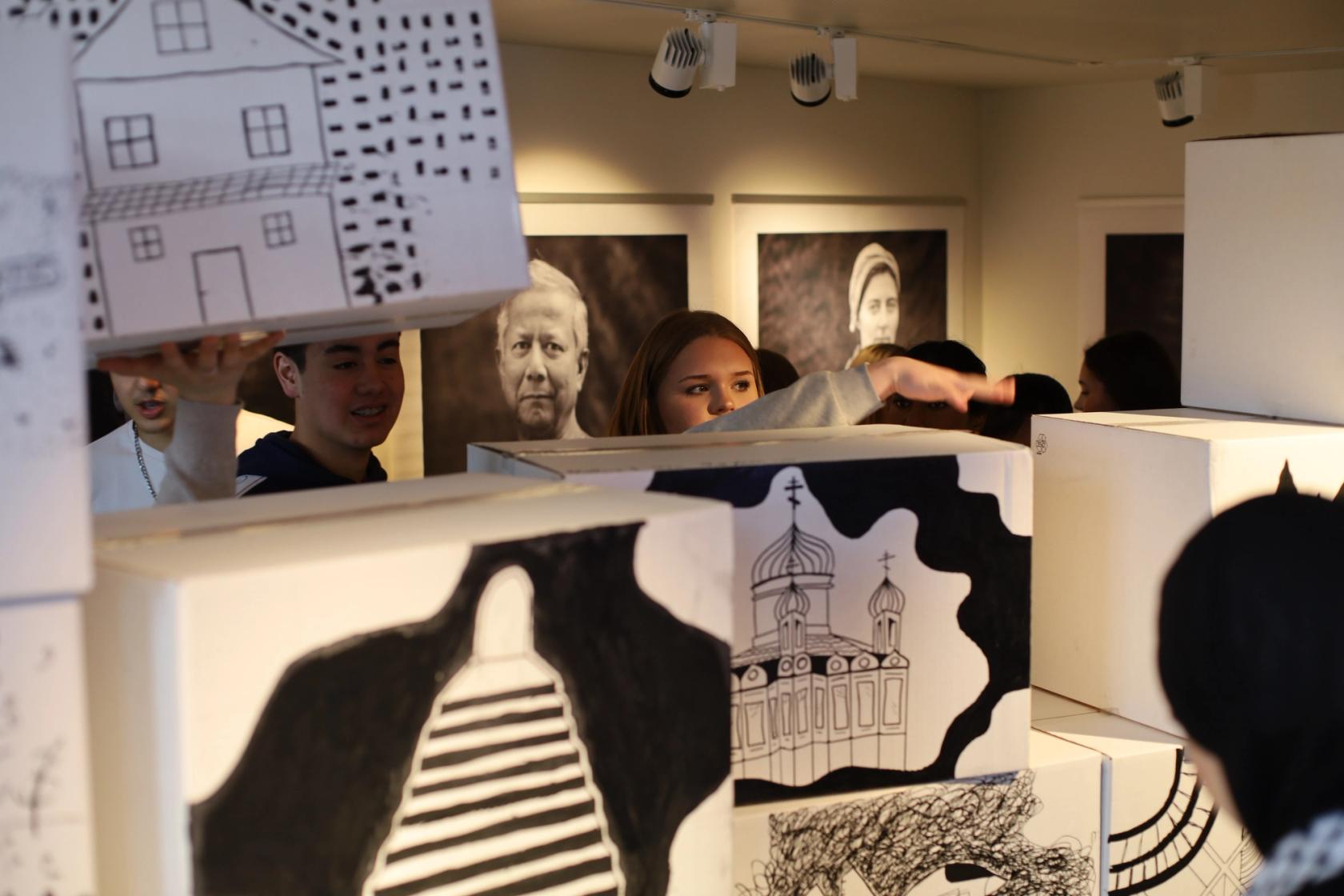 Elever på Pop-utstilling på Nobels fredssenter, elevarbeider og fotografier fra "På sporet av frihet" av Tom Hatlestad.