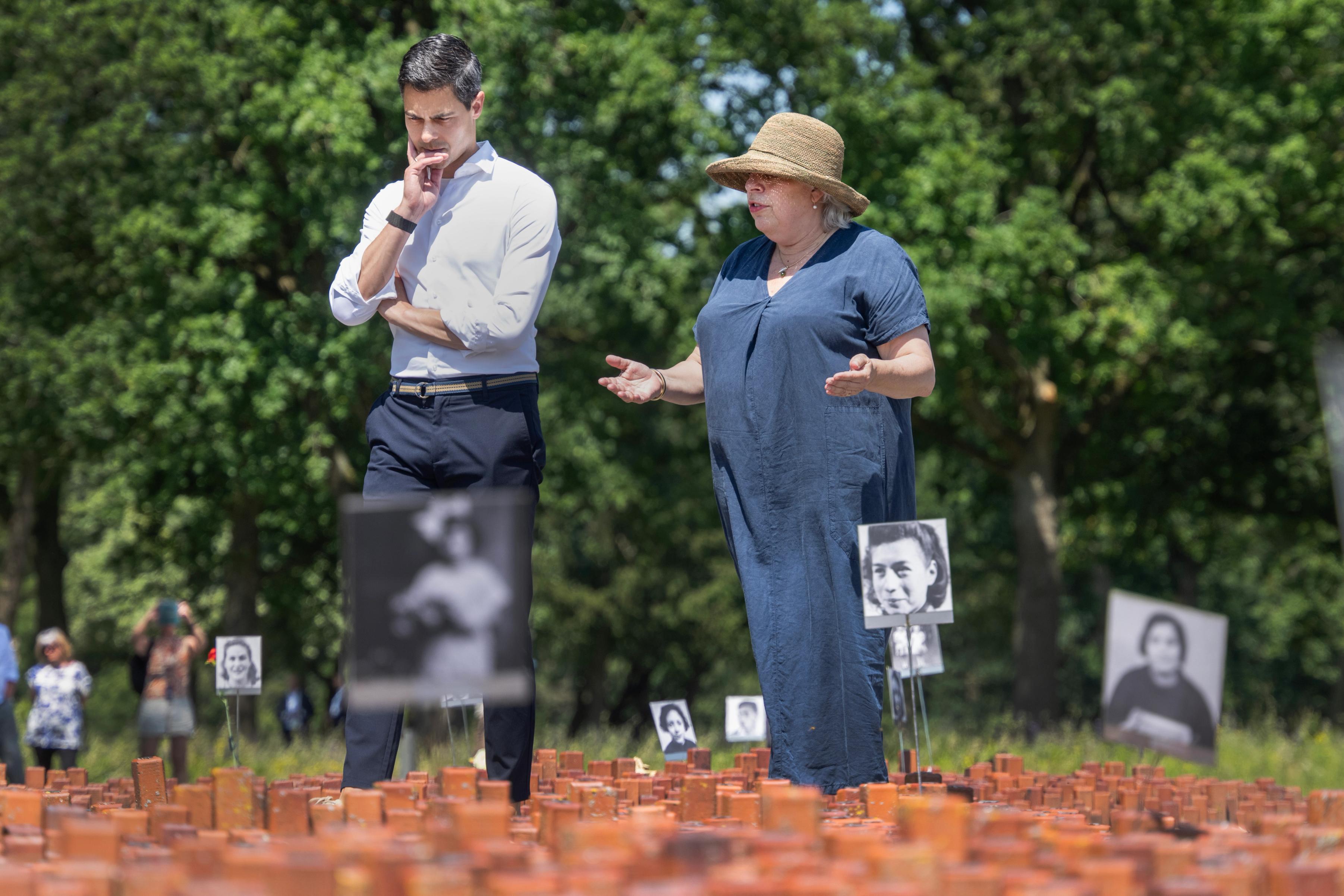 Minister-president Rob Jetten kijkt samen met directeur Bertien Minco naar het 102.000 Stenen Monument bij kamp Westerbork