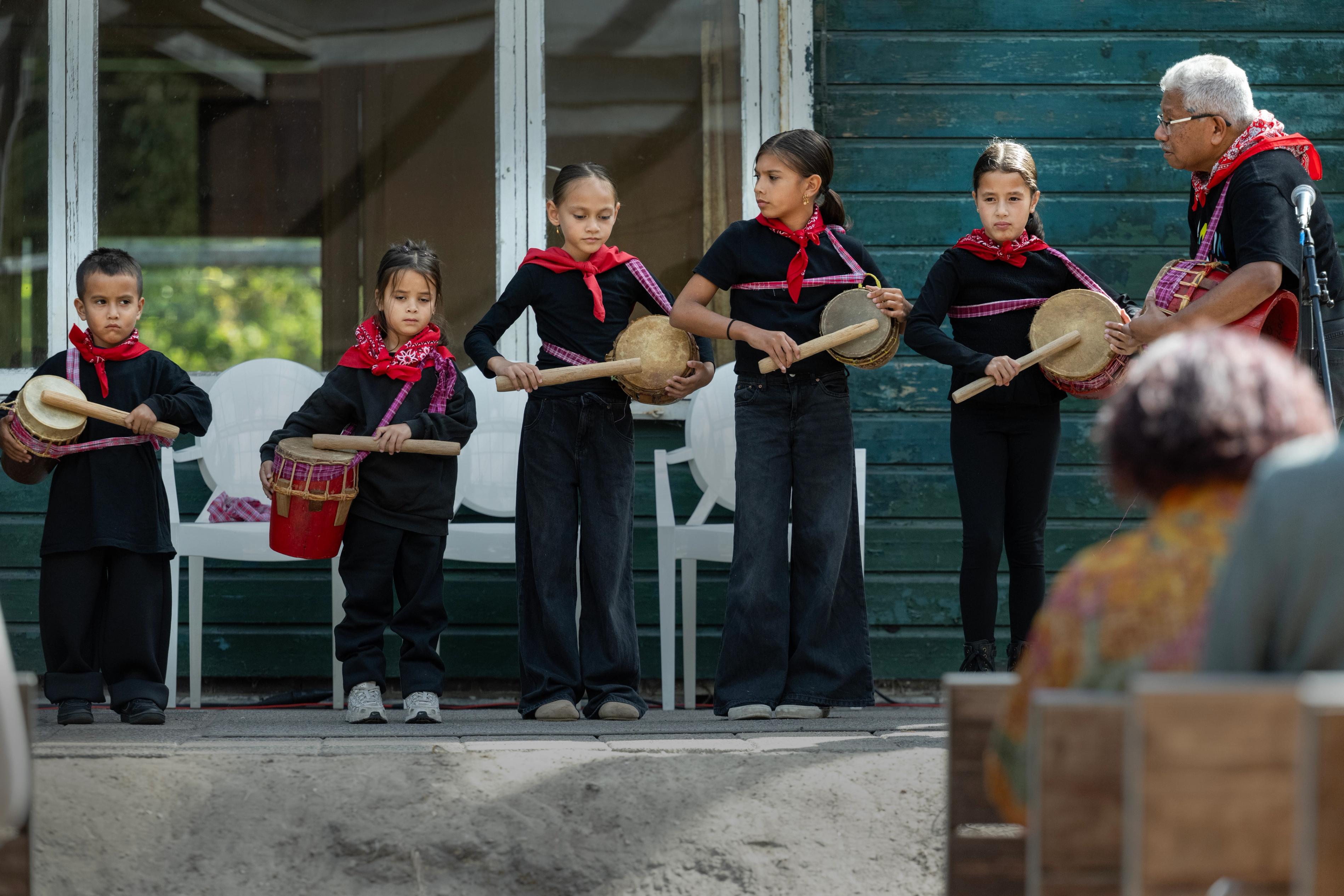 Molukse kinderen maken muziek op trommels