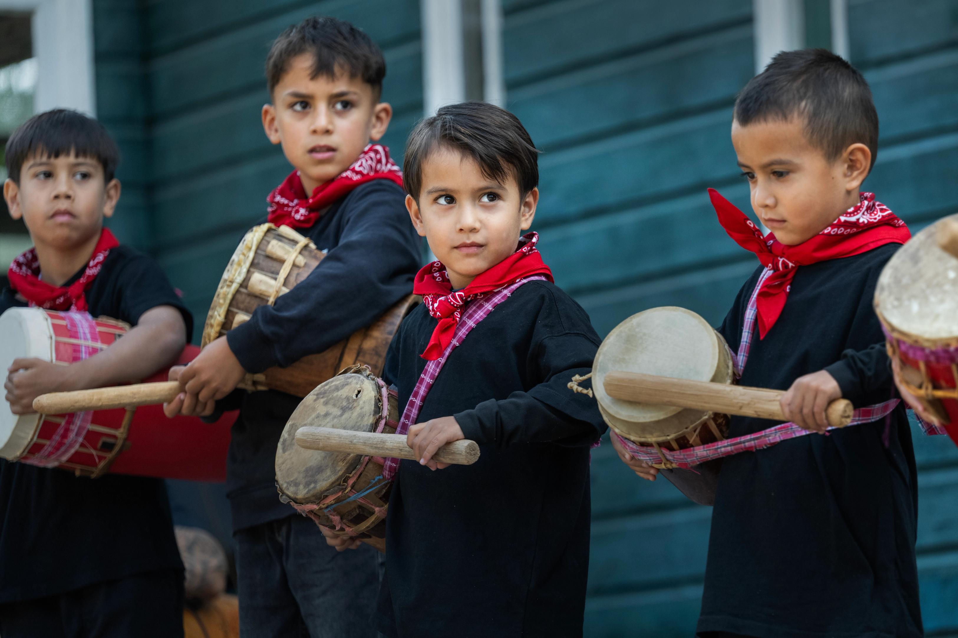 Molukse kinderen maken muziek op trommels 