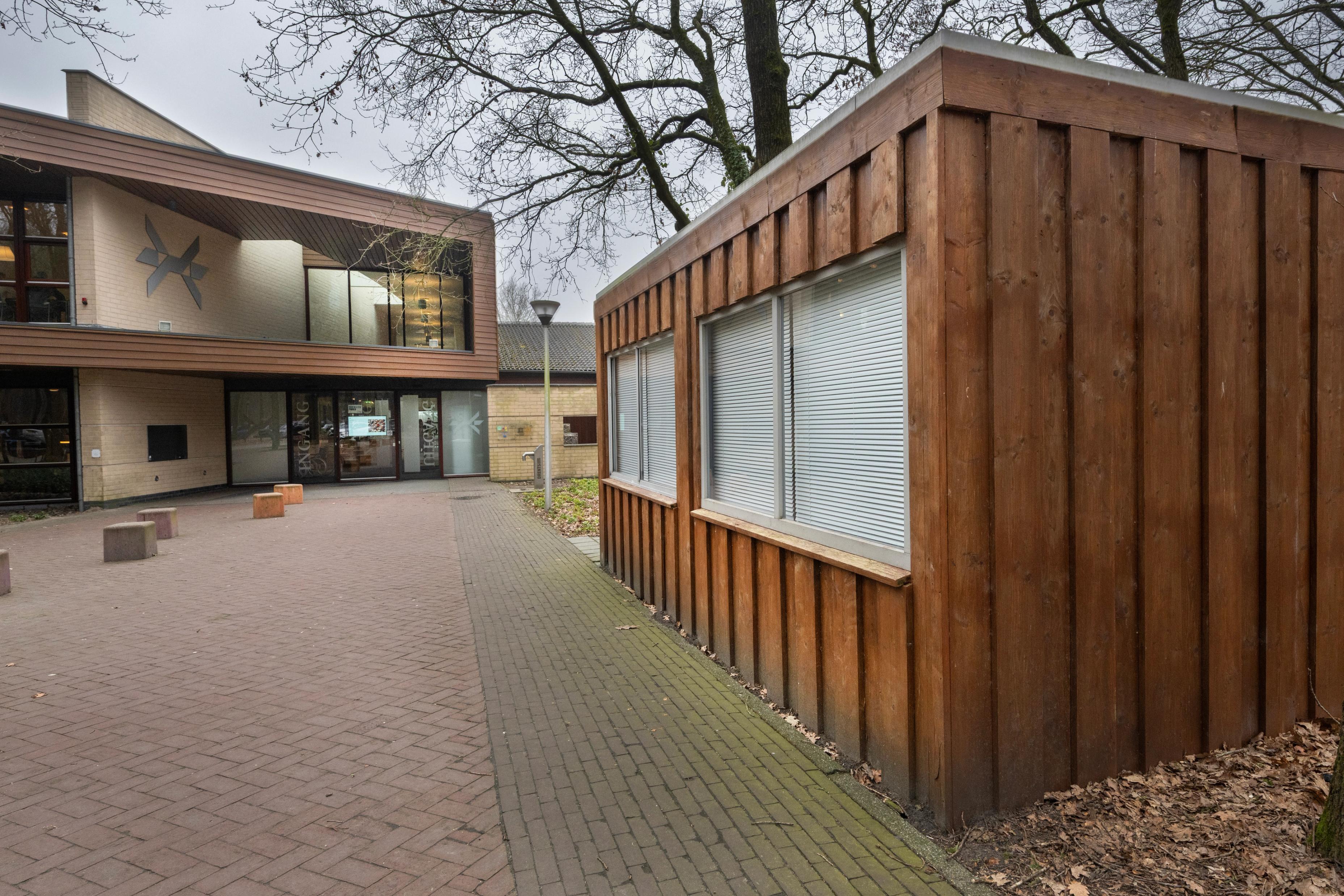 Zijkant van het bijgebouwtje op het plein voor Herinneringscentrum Kamp Westerbork, met op de achtergrond de ingang tot het museum