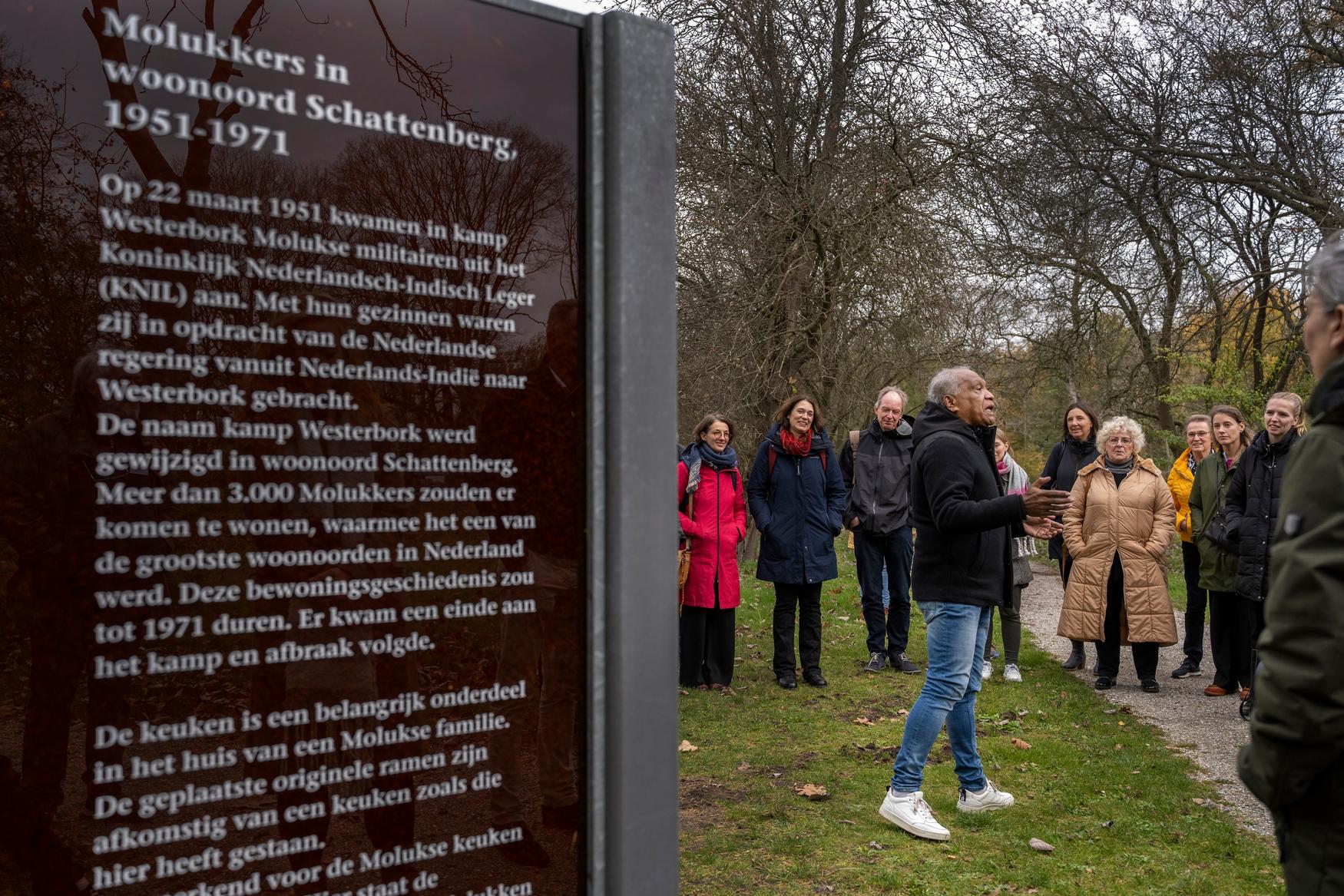 Foto van een oud-bewoner van voormalig woonoord Schattenberg die een rondleiding geeft aan een groep bezoekers