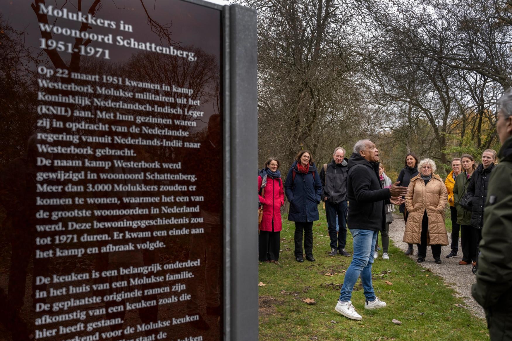 Foto van een oud-bewoner van voormalig woonoord Schattenberg die een rondleiding geeft aan een groep bezoekers