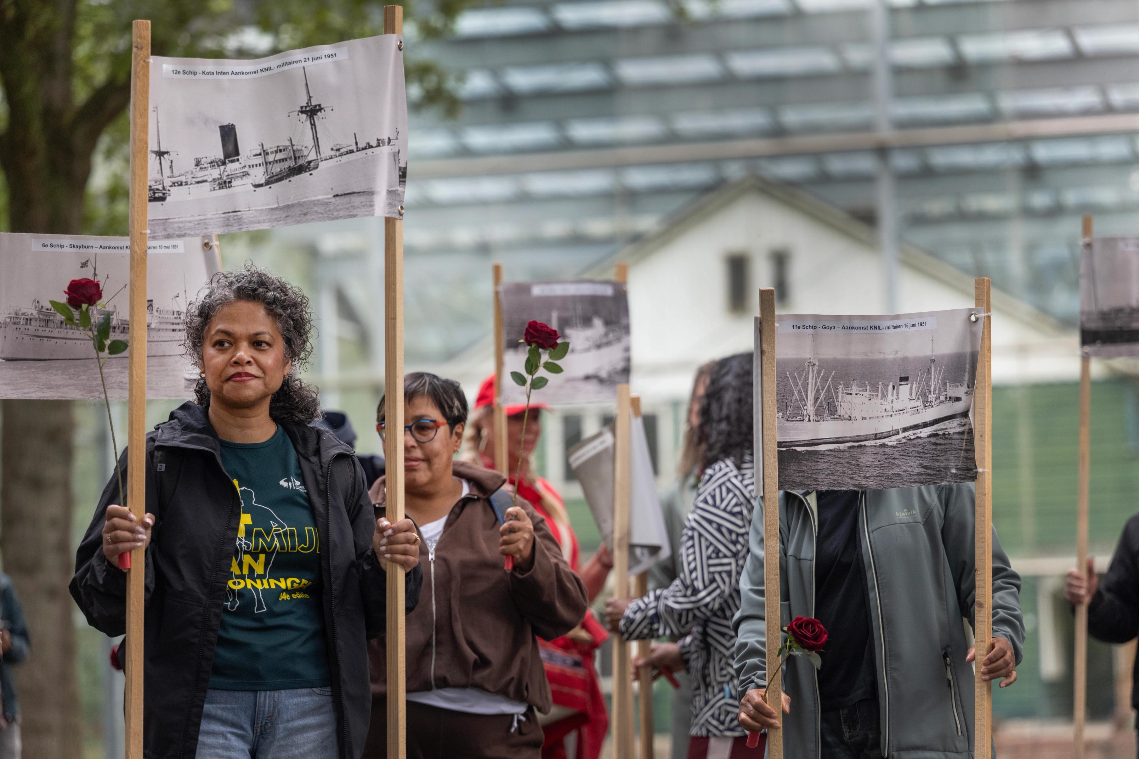 Vrouwen dragen spanddoeken voor de herdenking van de aankomst van Molukkers in voormalig kamp Schattenberg