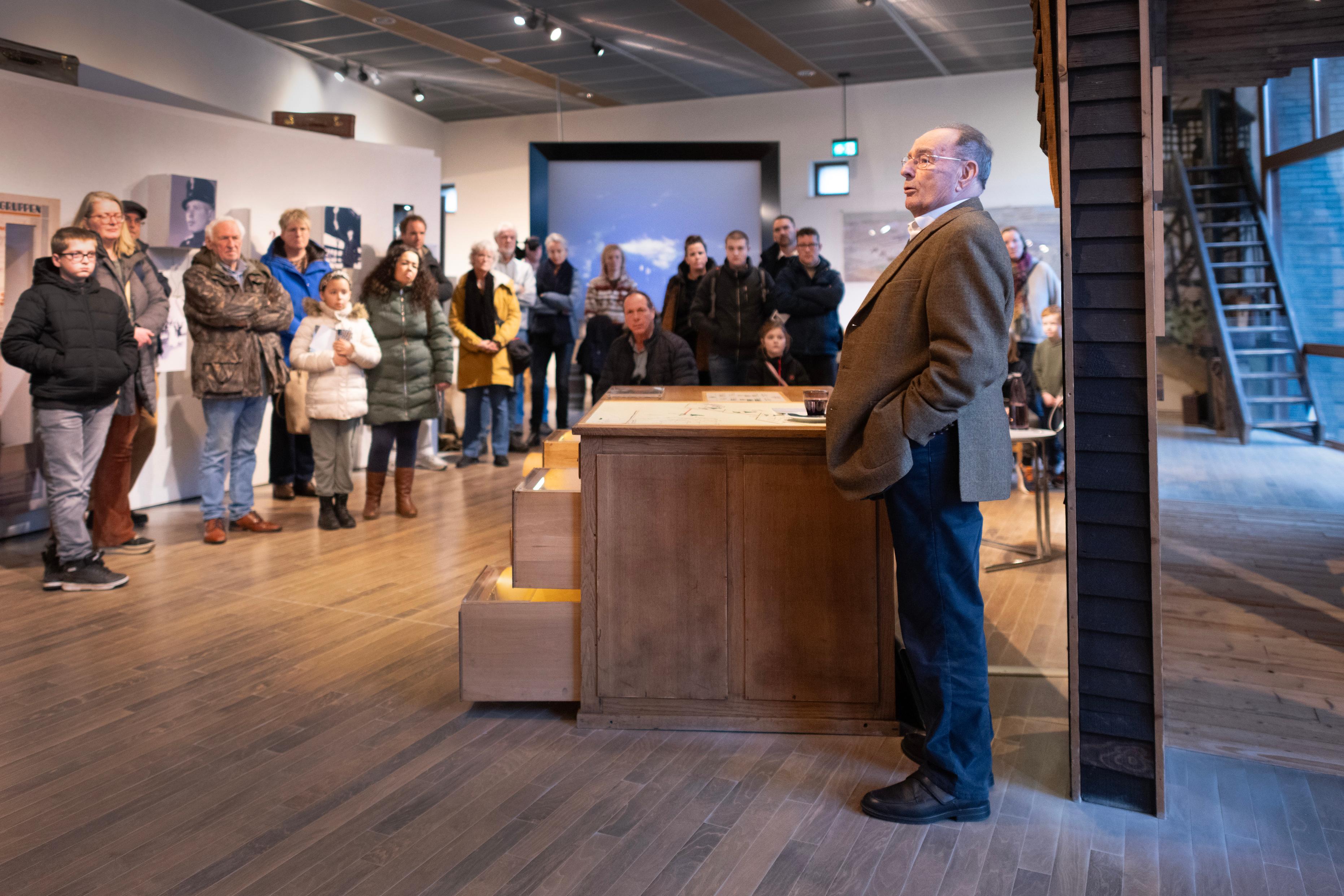 Oudere man (ooggetuige) spreekt voor een groep in het museum van Herinneringscentrum Kamp Westerbork