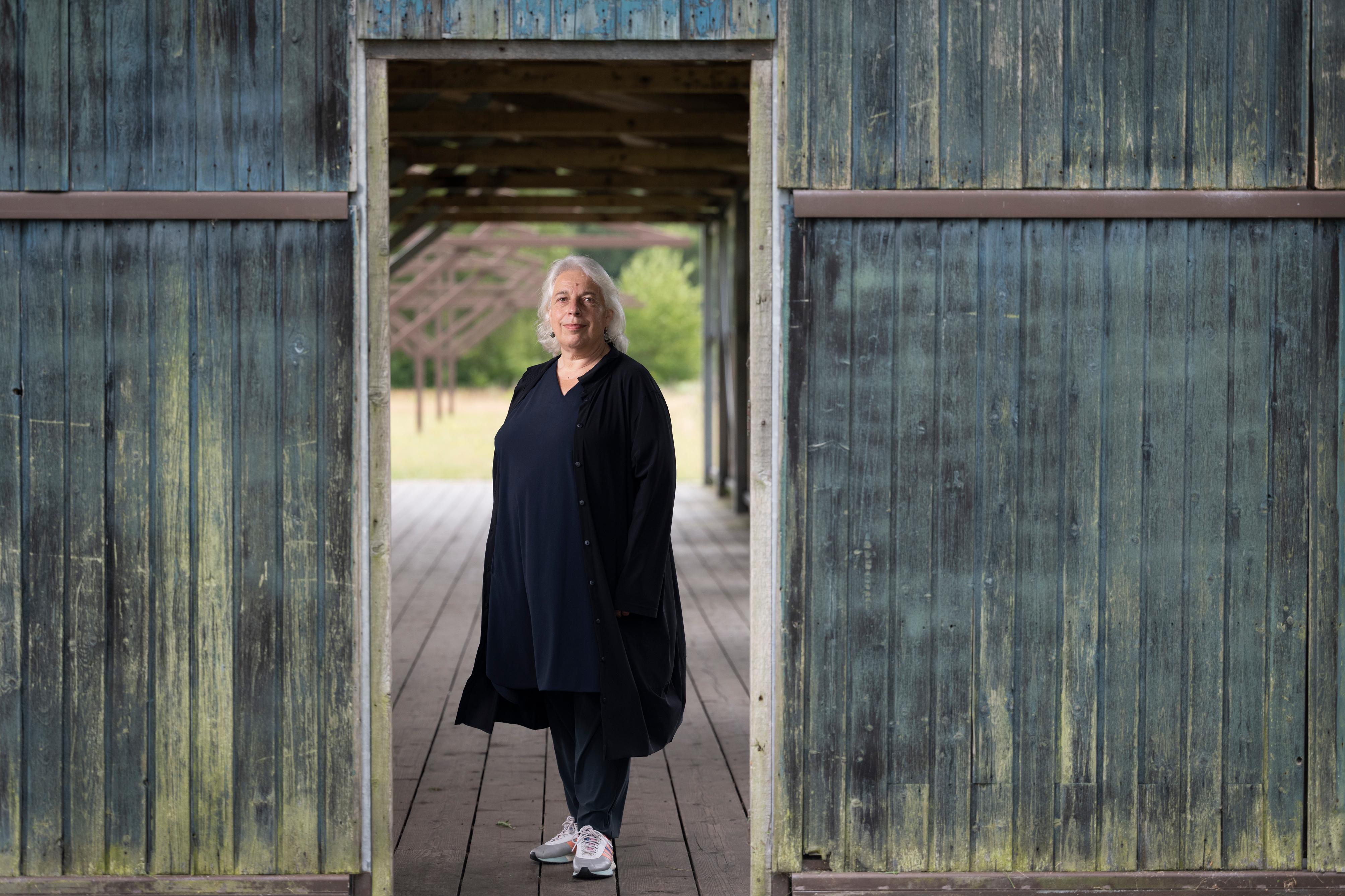 Directeur Bertien Minco van Herinneringscentrum Kamp Westerbork in de deuropening van de barak op het kampterrein