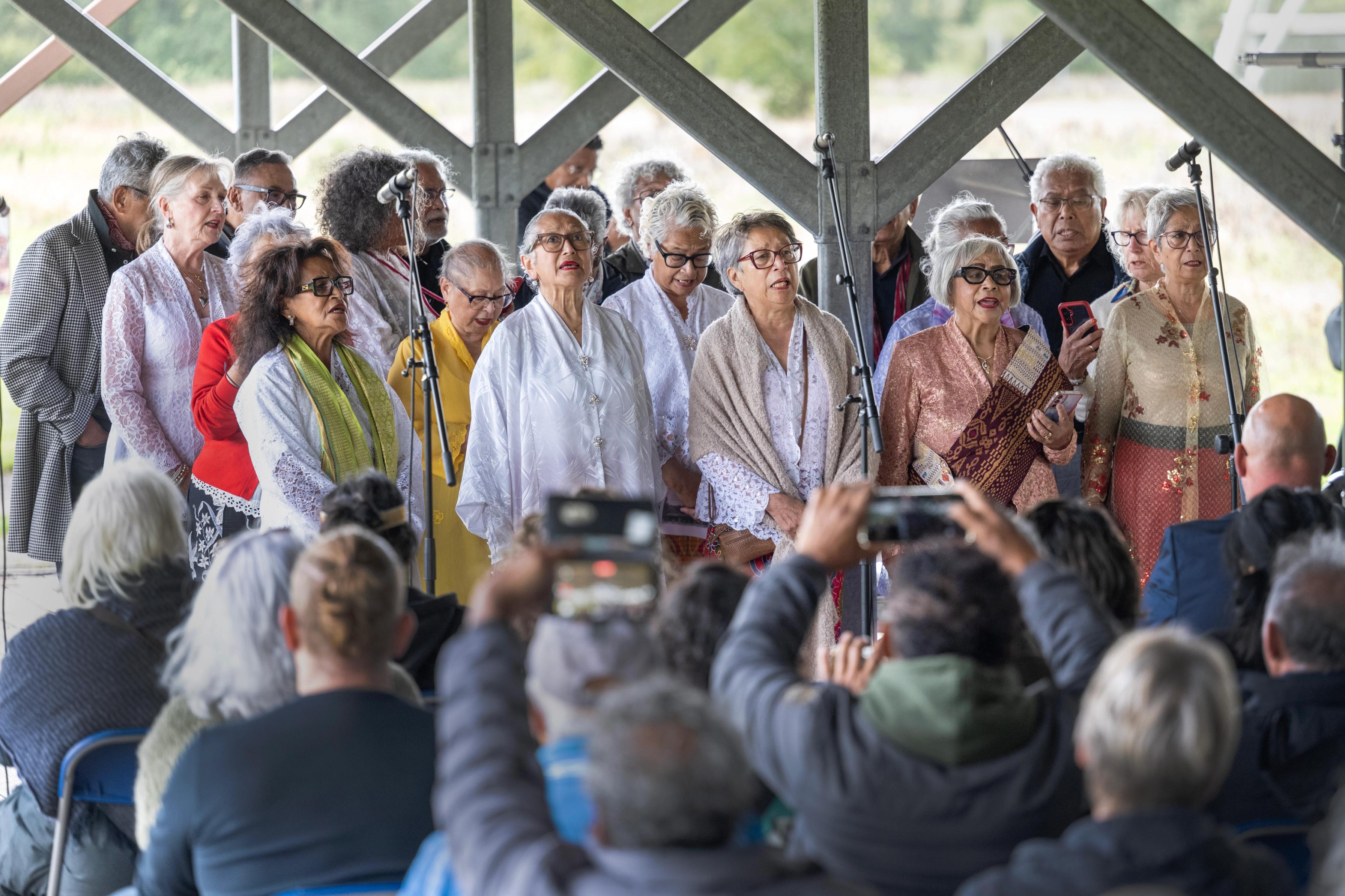 Een groep Molukse mannen en vrouwen zingt voor het publiek tijdens de herdenking van 75 jaar Molukkers in Nederland