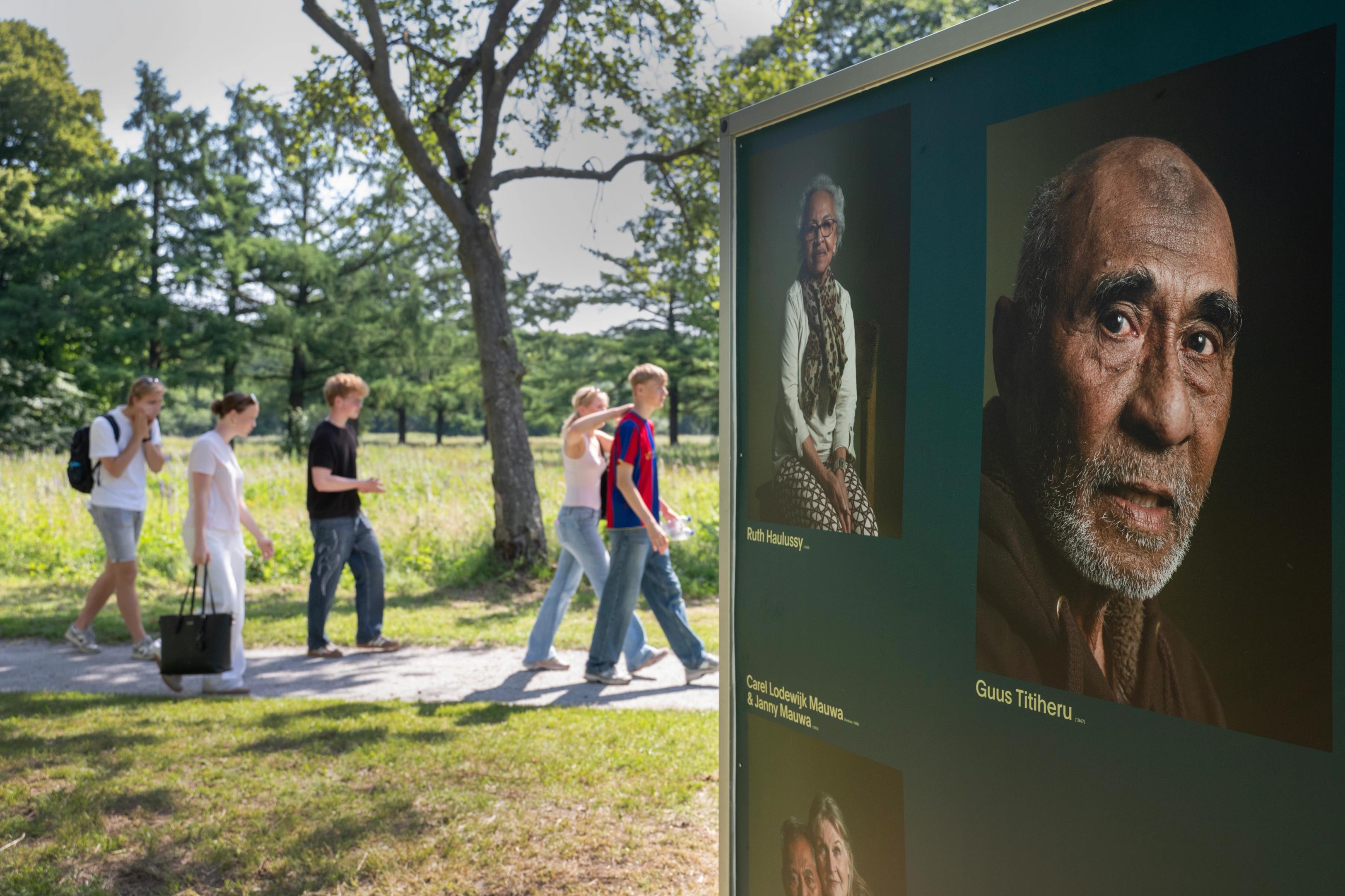 Kinderen lopen langs een blok met foto's, als onderdeel van een kunstinstallatie op het voormalig kampterrein van kamp Westerbork