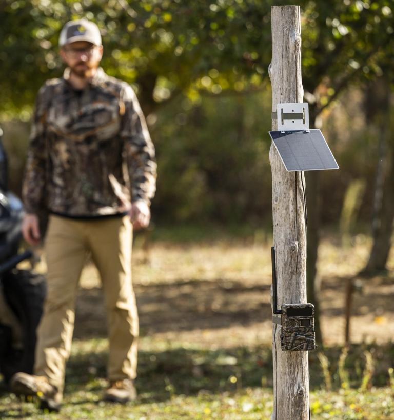 Ben in the field with a Yellowstone trail camera