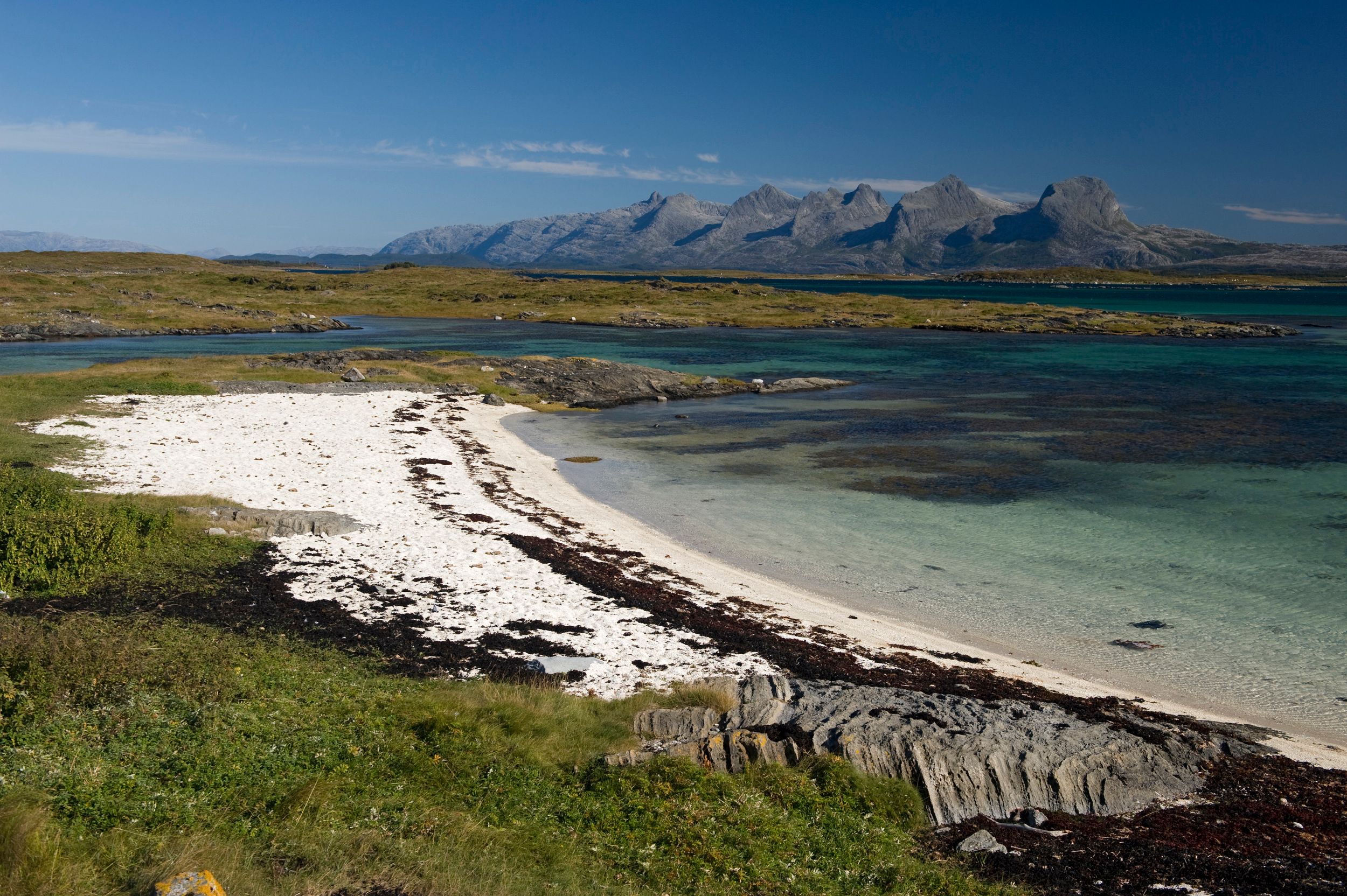 Strand på Herøy med De syv søstre i bakgrunnen