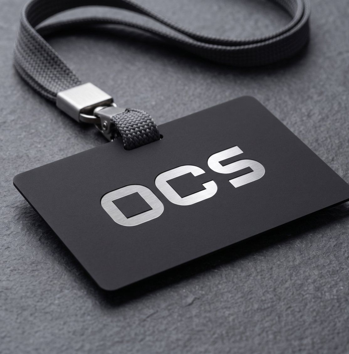 بطاقة تعريف سوداء بشعار OCS معلقة بشريط