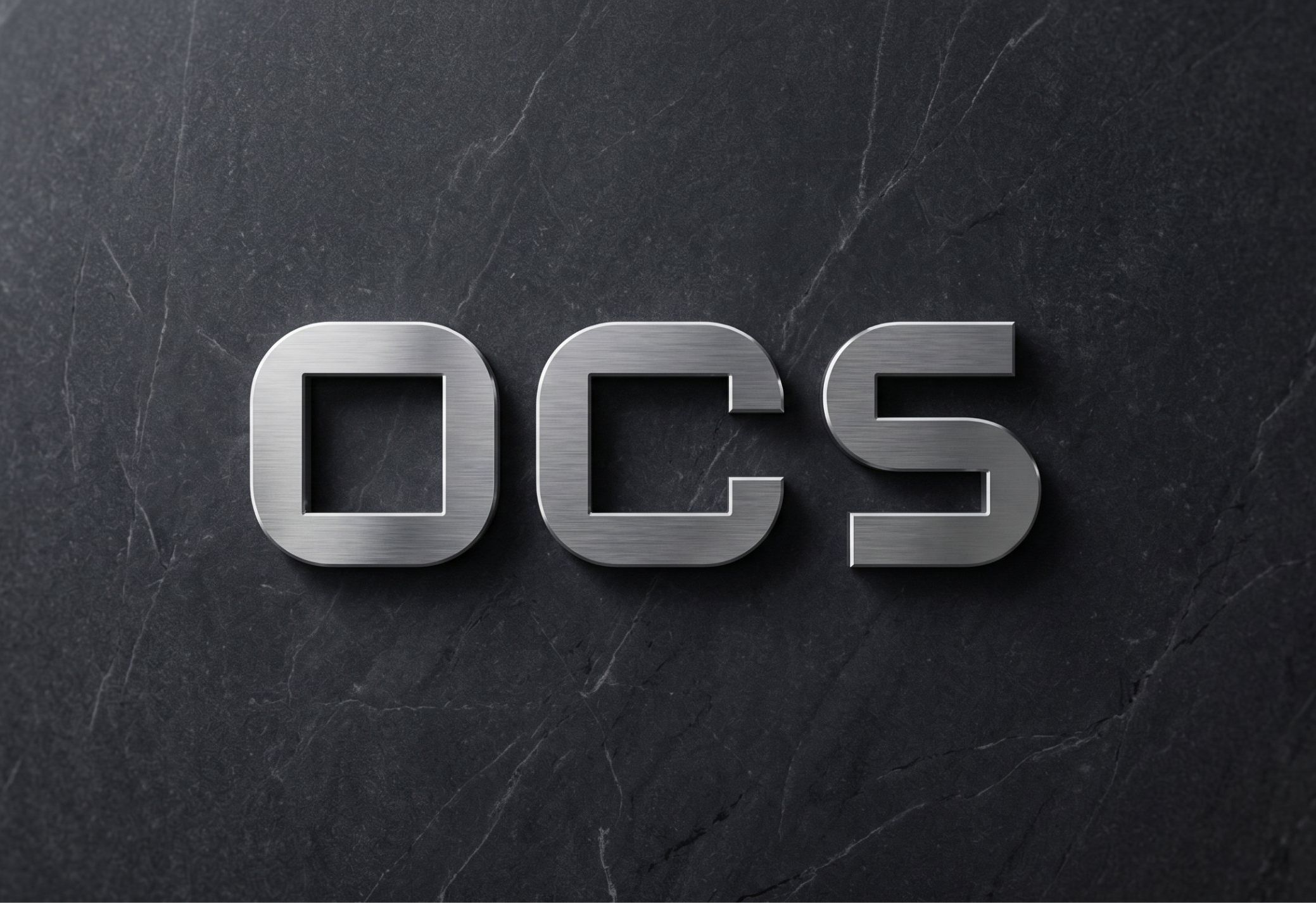 شعار OCS معدنياً على سطح حجري داكن