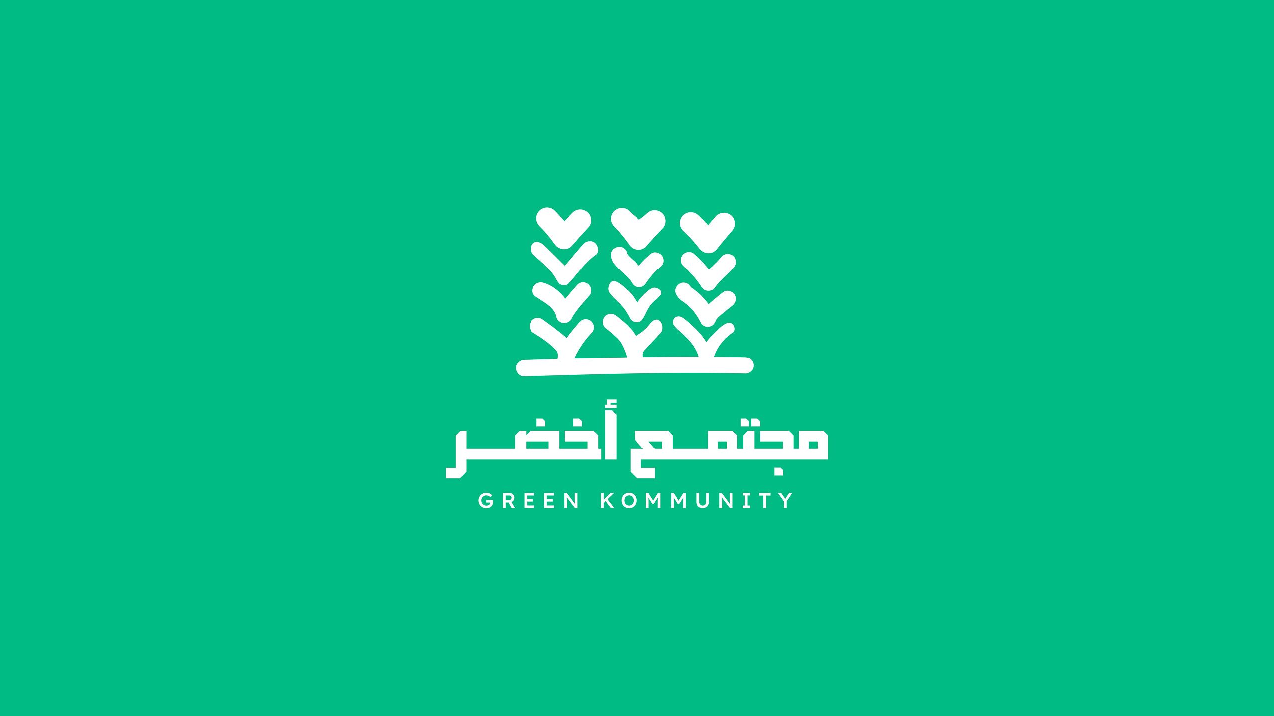 شعار مجتمع أخضر: ثلاث سنابل خضراء رأس كل منها قلب، وتحتها اسم «مجتمع أخضر» بالعربية والإنجليزية
