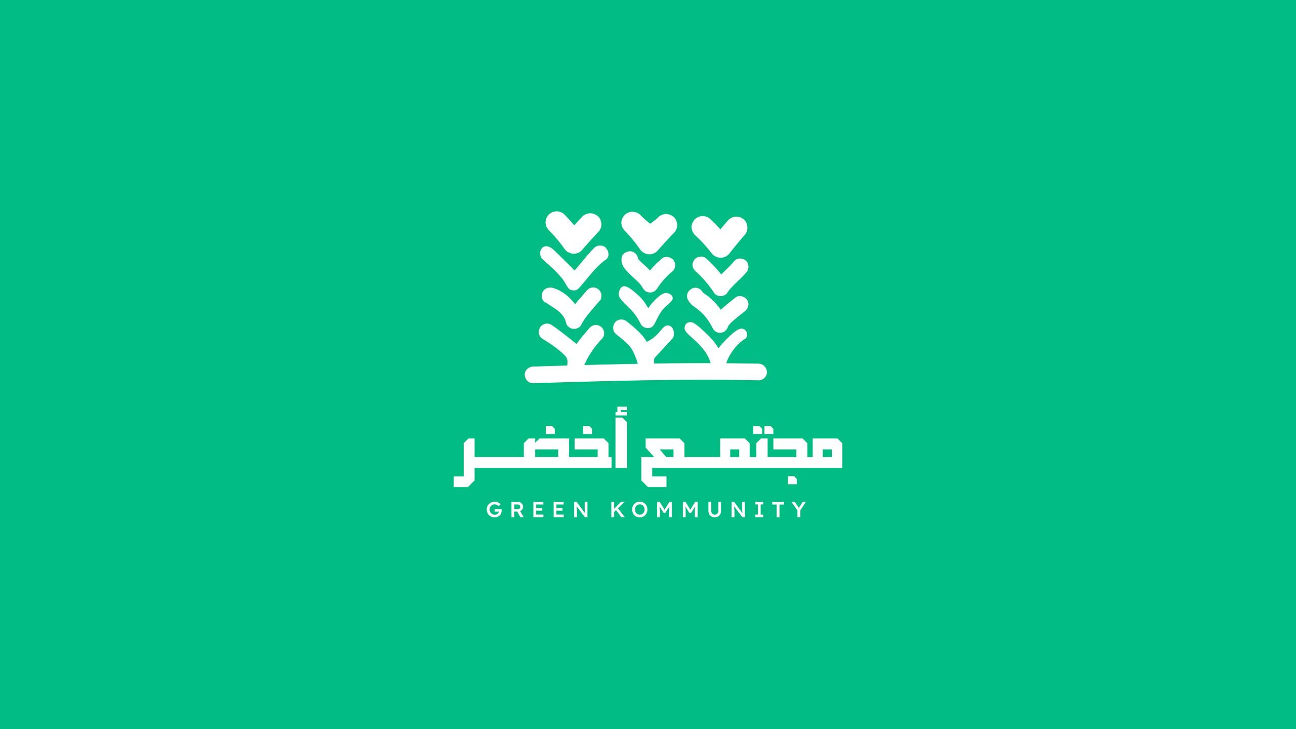 شعار مجتمع أخضر: ثلاث سنابل خضراء رأس كل منها قلب، وتحتها اسم «مجتمع أخضر» بالعربية والإنجليزية