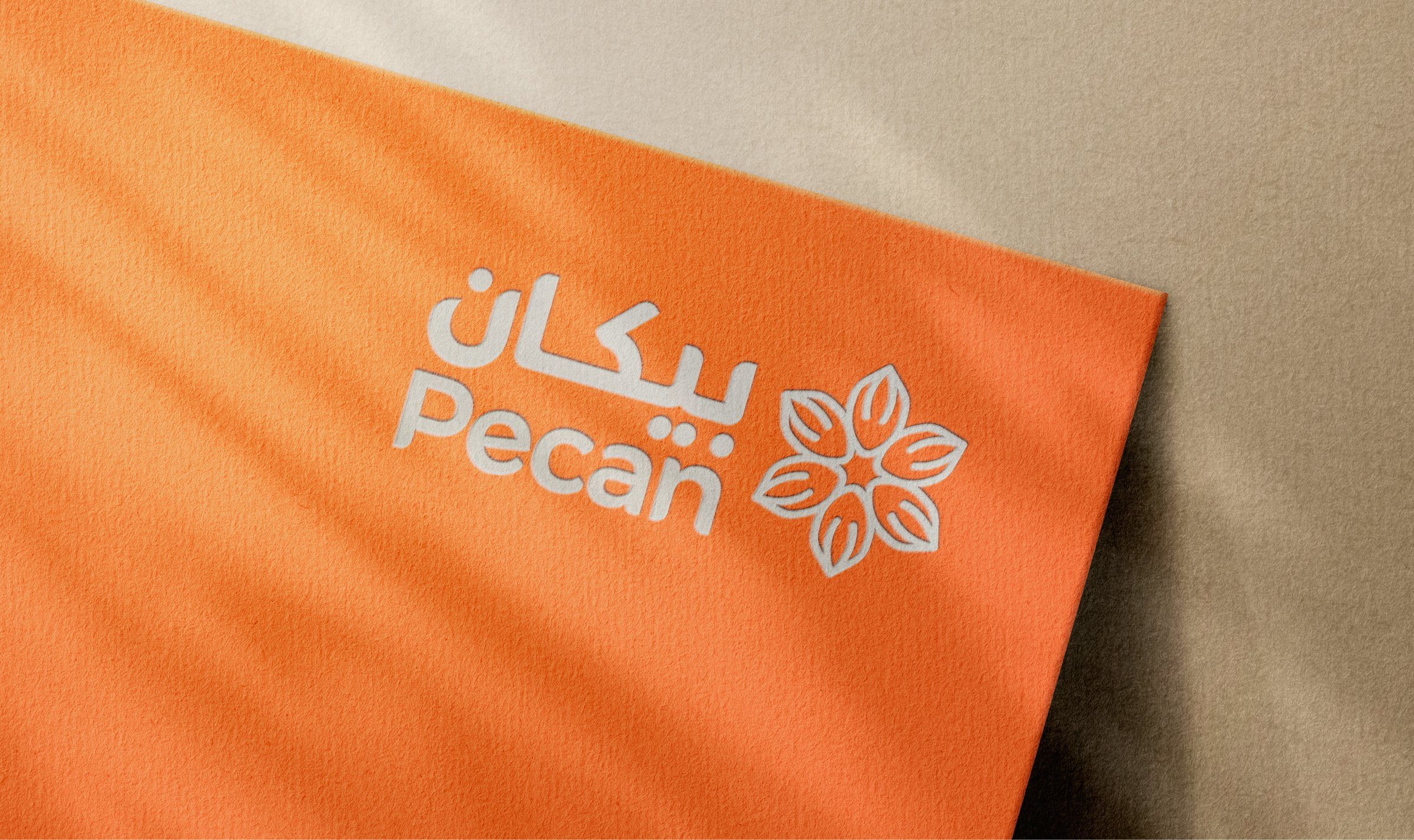شعار بيكان مطبوعاً بالأبيض على بطاقة برتقالية
