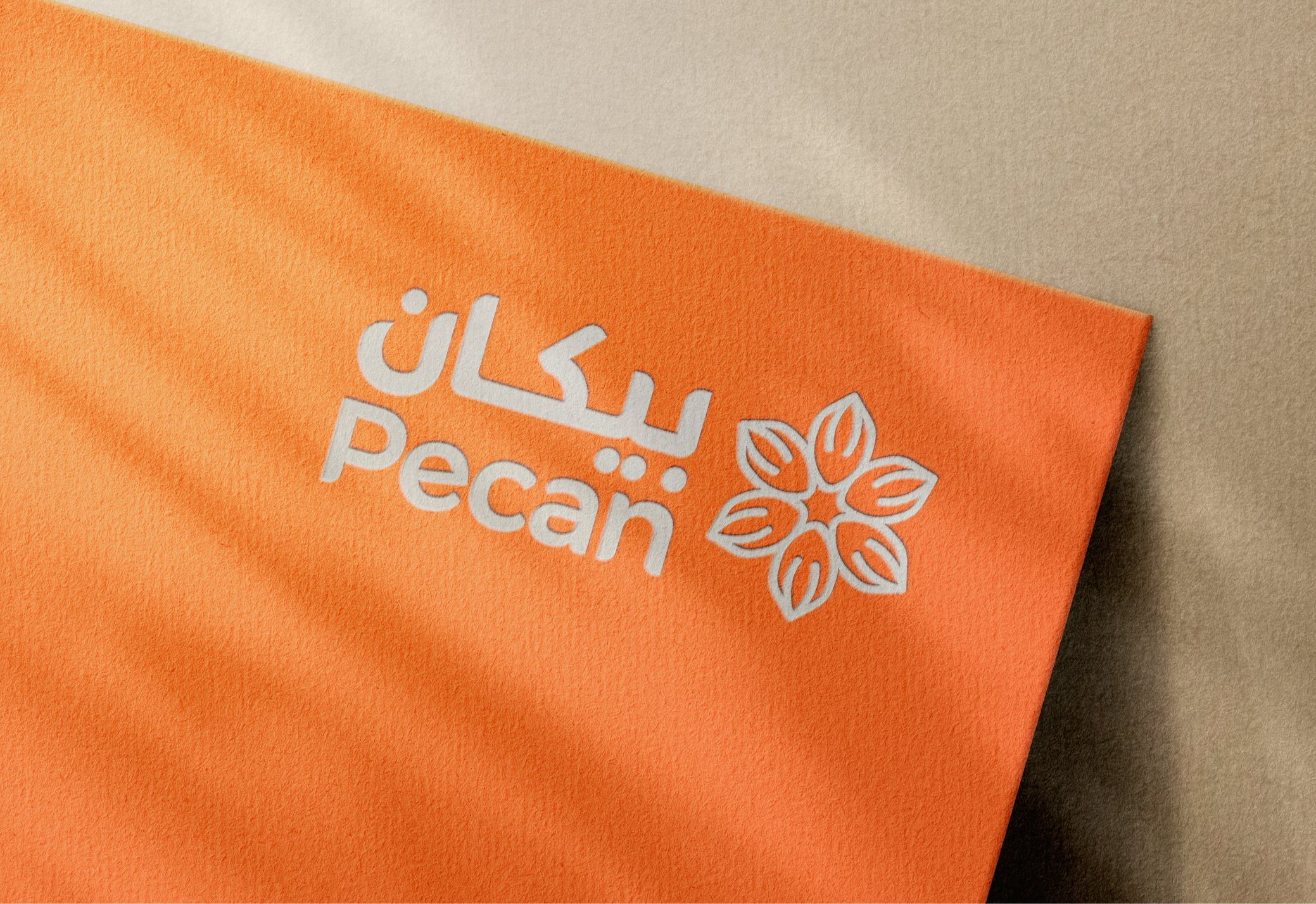 شعار بيكان مطبوعاً بالأبيض على بطاقة برتقالية