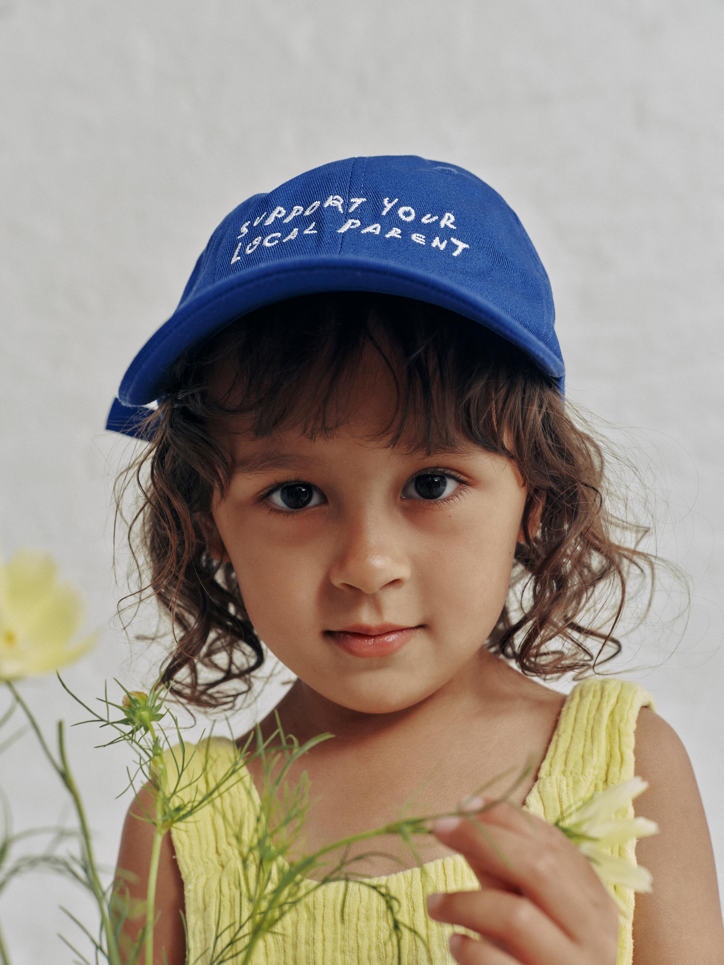 A little girl wearing the SYLP classic cap in electric blue.