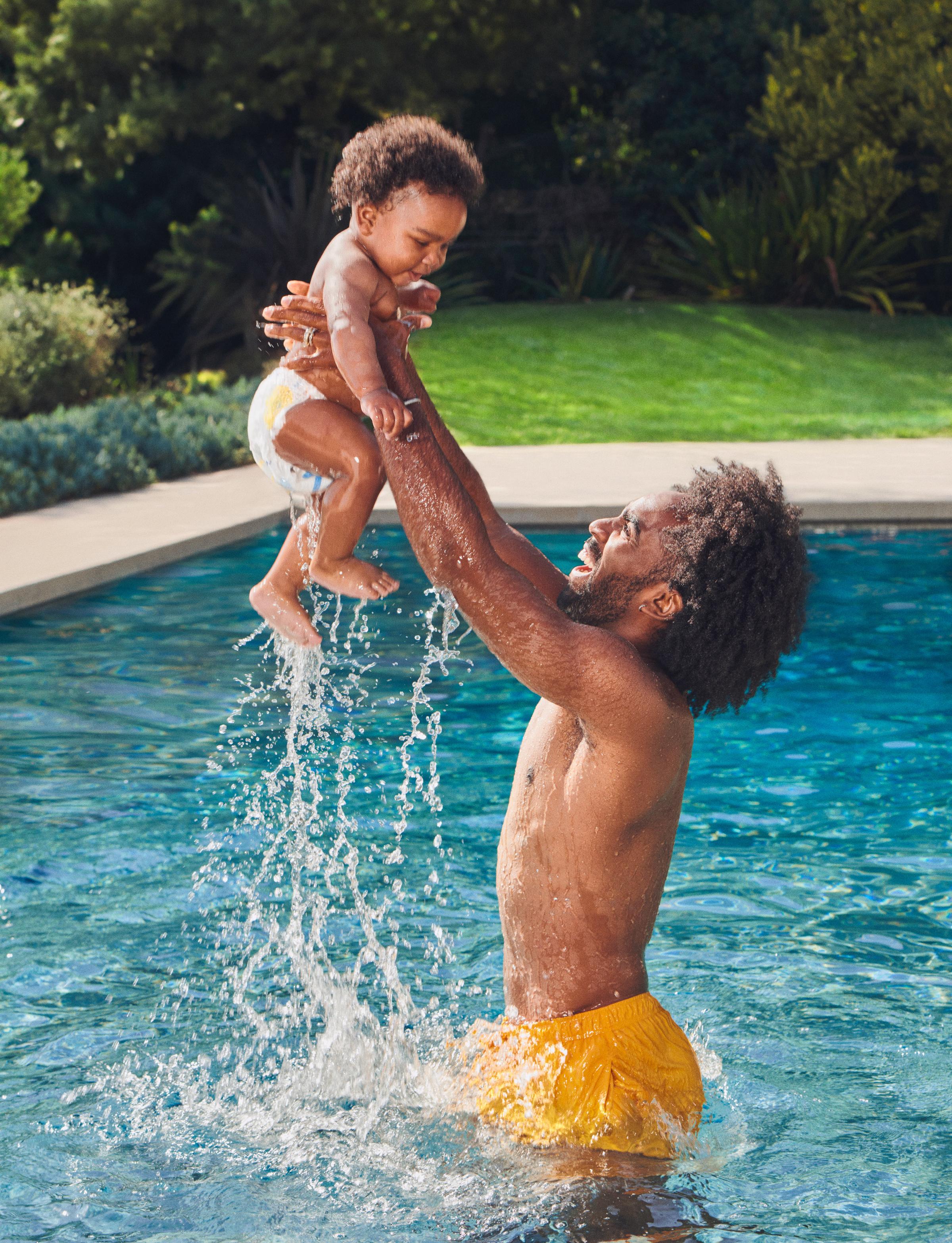 A man and baby playing in a pool