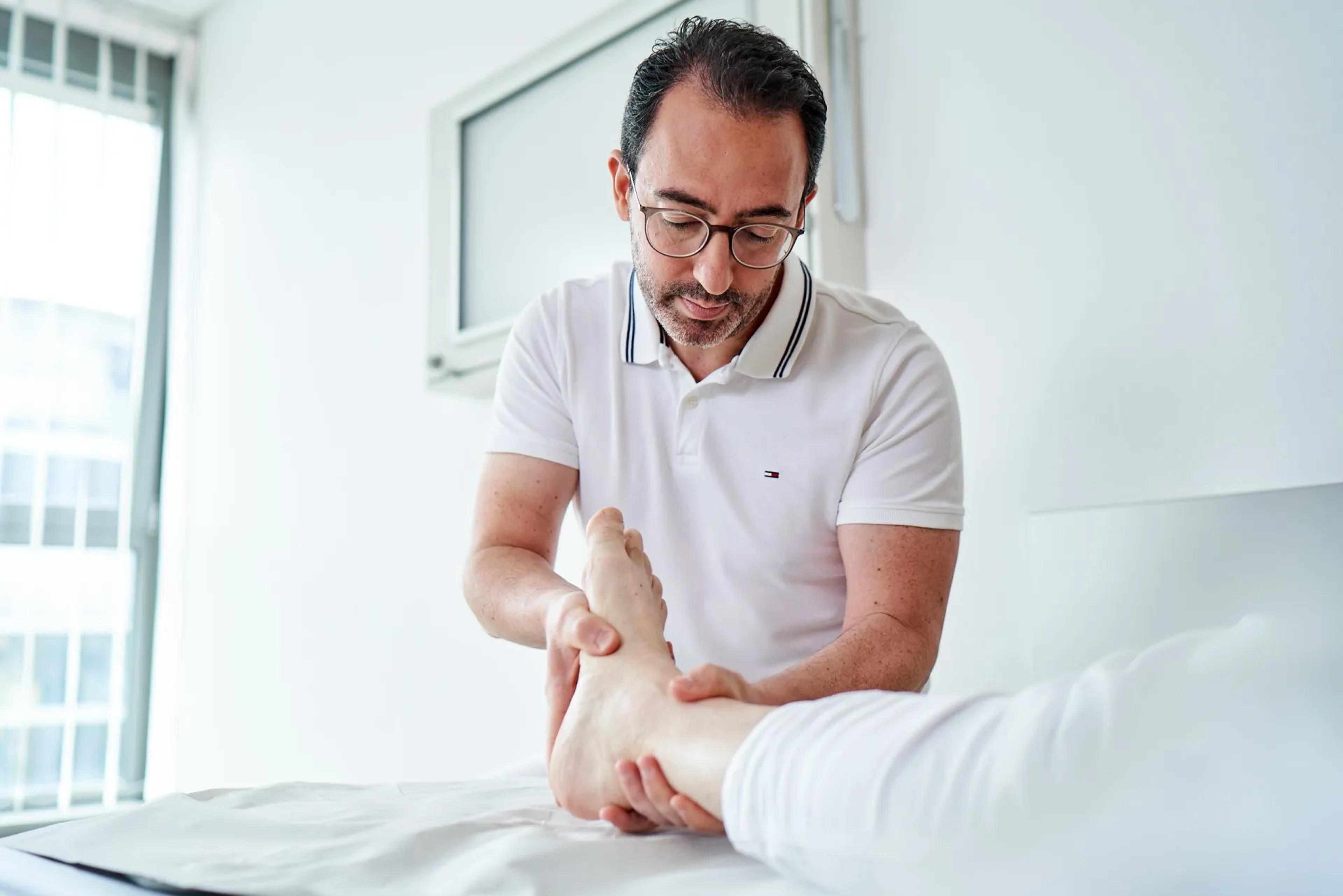 Arzt der einen Fuß therapiert