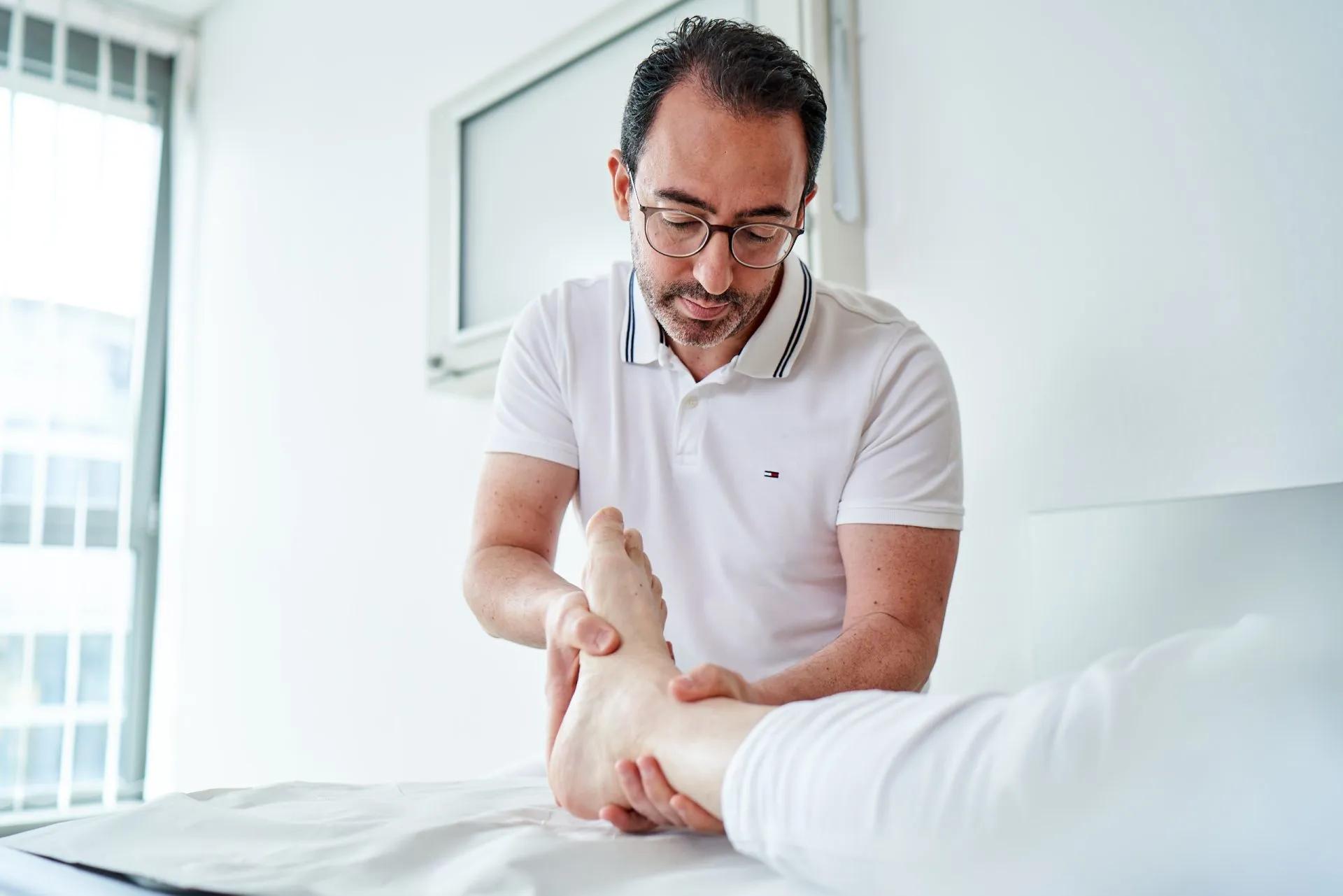 Arzt der einen Fuß therapiert