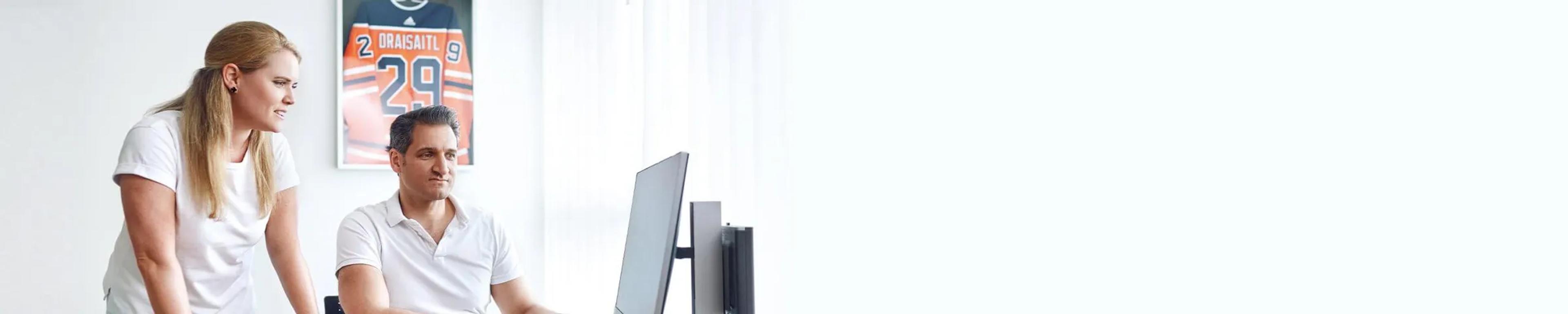 Dr. Theresa Schäferhoff und Dr. med. Bannerjee schauen sich Befunde auf dem Computer in ihrem Büro an.