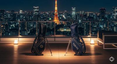 東京の夜景を背景に、モダンなルーフトップテラスで向かい合う2つの高級ゴルフバッグ。世界的ブランドと東京ブランドの対決を象徴し、上品で統一感のある質感で描かれている。