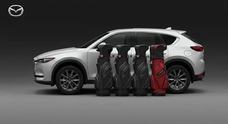 CX-8の荷室に4つのゴルフバッグが整然と積まれ、スマートな積載性を示すイラスト。上品で統一感のあるトーン。画像の端にマツダロゴあり。