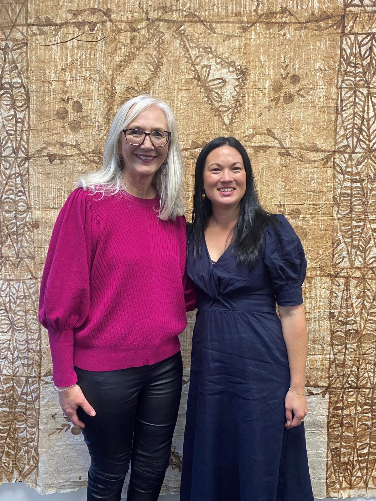 Two women standing and smiling for the camera