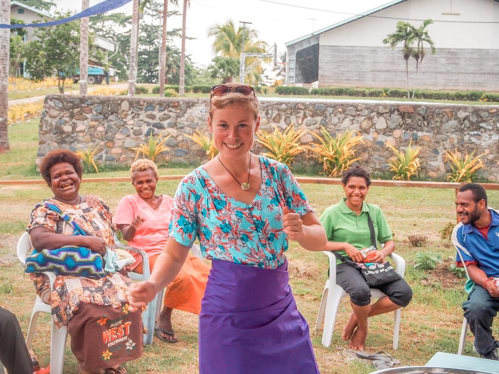 a woman is dancing in front of a group of people sitting in chairs .