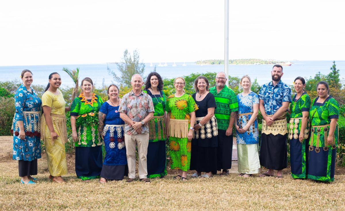 A group of people standing side by side and smiling for the camera. A group of people standing side by side and smiling for the camera.