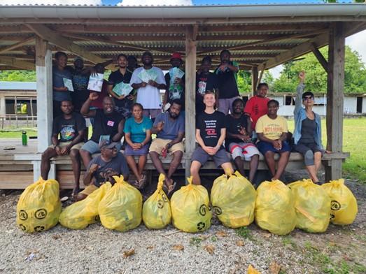 A large group of people smile for the camera with the bags full of rubbish they just collected A large group of people smile for the camera with the bags full of rubbish they just collected