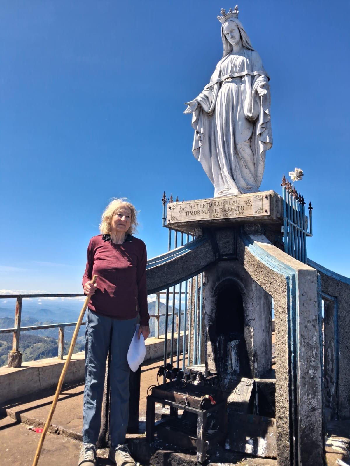 Pauline stands in front of a statue of the Virgin Mary.