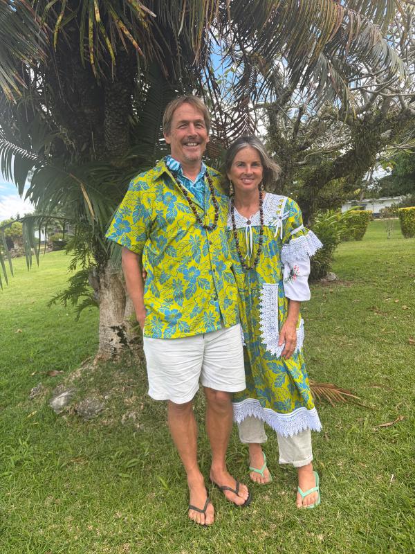 A couple wearing matching cultural attire and smiling for the camera A couple wearing matching cultural attire and smiling for the camera