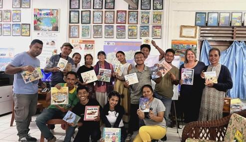 A group of people holding books and smiling for the camera. A group of people holding books and smiling for the camera.