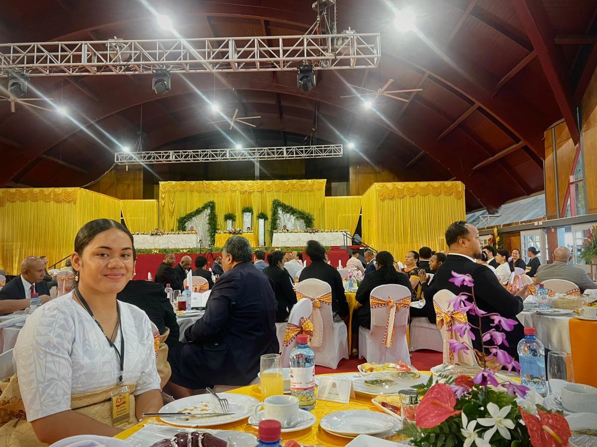 A young woman seated at a table smiling