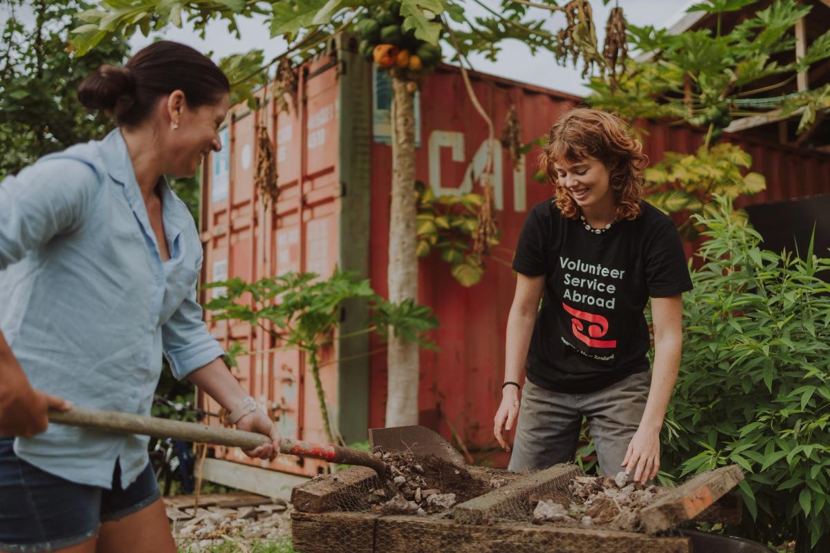 Two young women smiling and working together in the outdoors