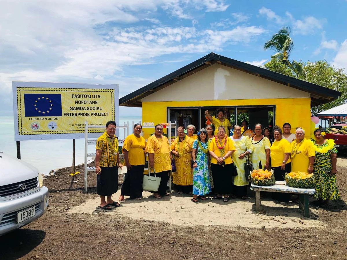 A large group of people mostly dressed in yellow attire in front of a building.