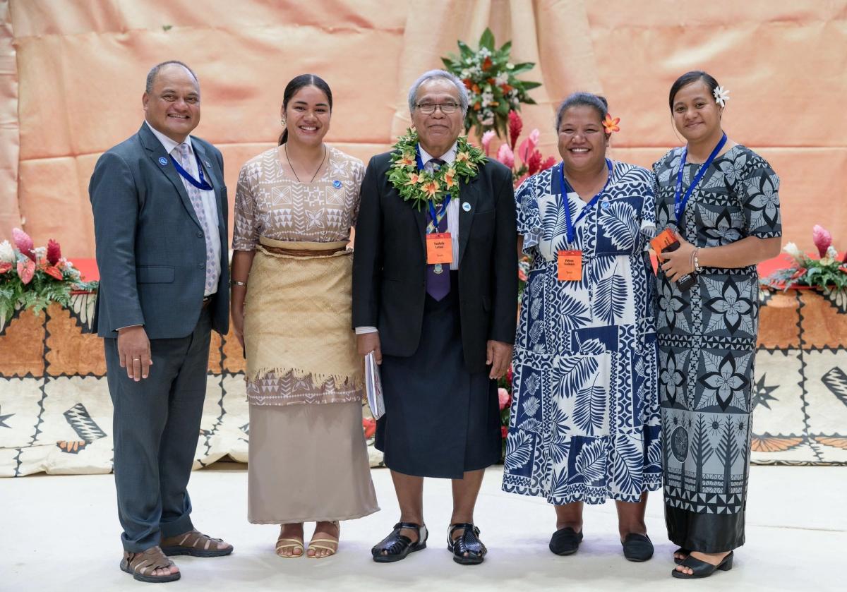 A group of people standing and smiling for the camera
