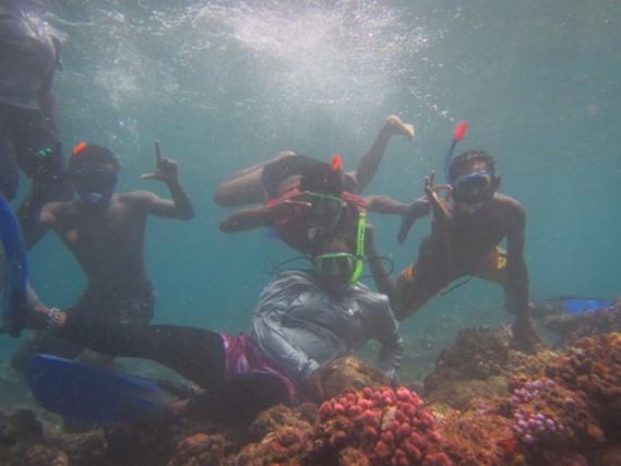 A group of people pose for the camera underwater A group of people pose for the camera underwater