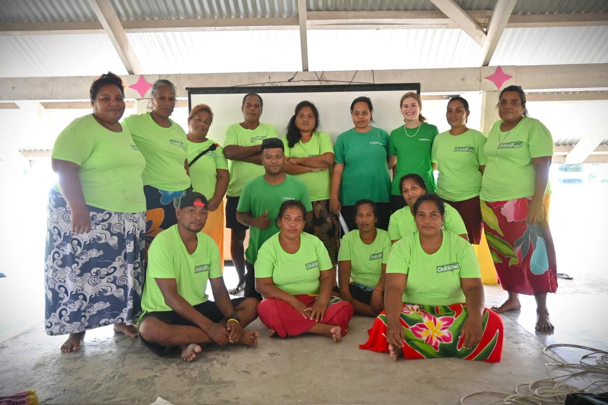 A group of people wearing a green uniform smile for the camera A group of people wearing a green uniform smile for the camera